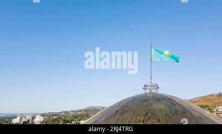 Almaty, Kazakhstan - August 17, 2023: The flag of Kazakhstan floats in the blue sky. The symbol of the country Stock Photo