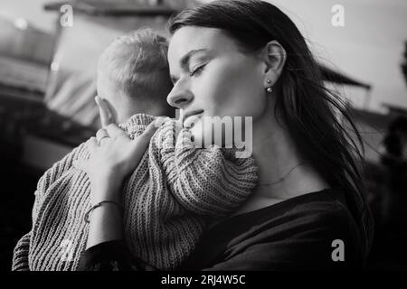 beautiful caucasian young woman hugging baby son. Black and white photo Stock Photo