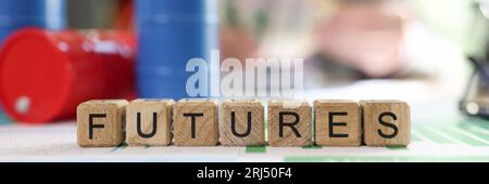 Word futures collected from wooden cubes with oil barrels and blurred business person in background. Stock Photo