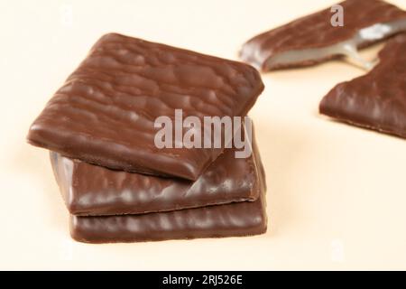 Dark chocolate bars with filling, one broken into two parts, on a pastel background.Close up Stock Photo