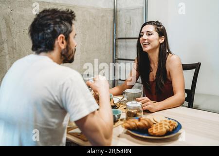 Young happy couple in love having breakfast at the kitchen table Stock Photo
