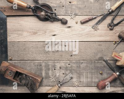 Vintage carpenter tools as a frame on a rustic wooden workbench with space for text, workshop concept Stock Photo