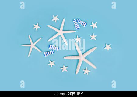White starfish and sandals on blue background Stock Photo