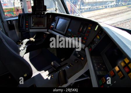 A modern train control panel with illuminated buttons in a dimly lit train control room Stock Photo