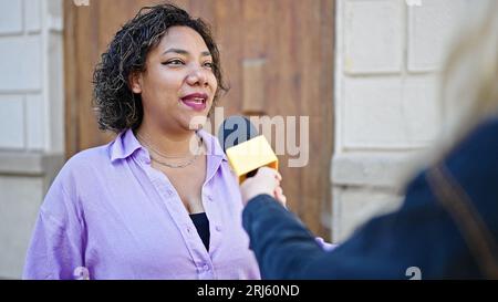 Young beautiful latin woman having interview at street Stock Photo