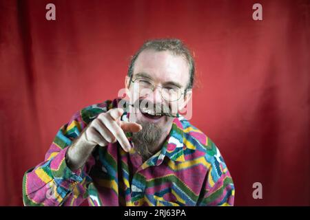 Hipster man with glasses and mustache pointing to camera laughing and teasing Stock Photo