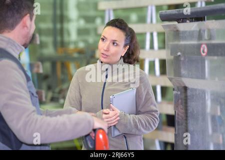 female manager talking to assistant manager in modern factory Stock Photo
