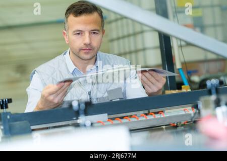 man using a roll machine in printer factory Stock Photo
