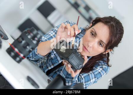 woman cleaning camera with brush Stock Photo