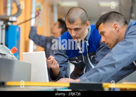 apprentices being shown computer control panel in factory Stock Photo