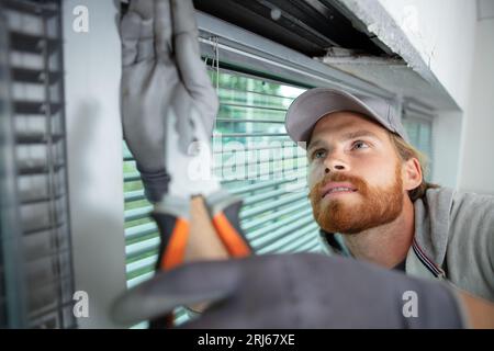 young man installing window blinds Stock Photo