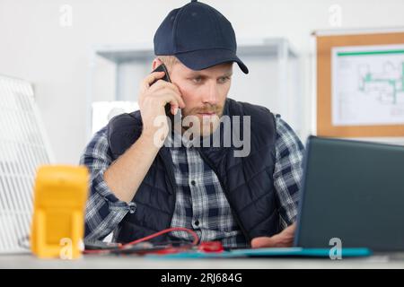 a young specialist repairs a laptop Stock Photo