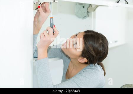 woman using screw driver for diy work Stock Photo