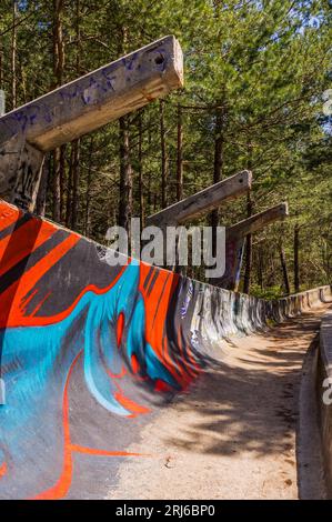 a mini skateboard ramp fully covered with graffiti in the middle of a forest Stock Photo