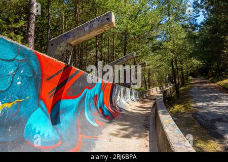 a mini skateboard ramp fully covered with graffiti in the middle of a forest Stock Photo