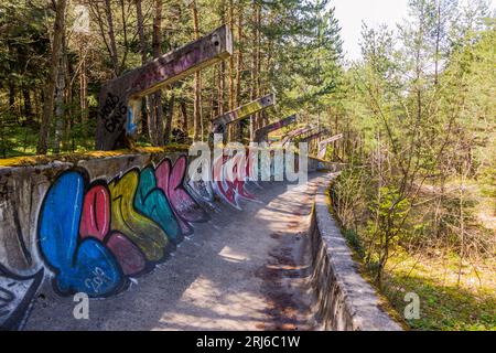 a mini skateboard ramp fully covered with graffiti in the middle of a forest Stock Photo