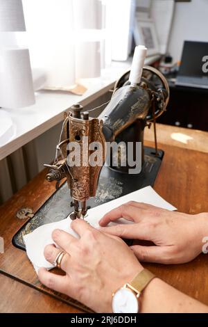 A hands of a woman working with a sewing machine in close up. Stock Photo