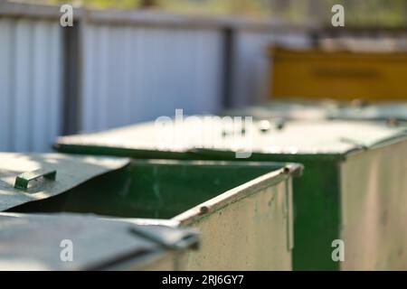 Large trash cans stand in a fenced area close-up Stock Photo