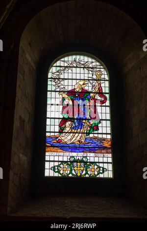 A vibrant stained glass window in a cathedral setting, featuring an array of bright colors and intricate designs Stock Photo