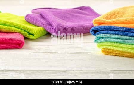 Stack of kitchen microfiber towels in bright colors on a white wooden background. Stock Photo