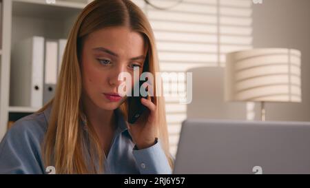 Caucasian girl talk to client on cellphone use laptop discuss deal woman businesswoman consultant agent at home office working with computer make Stock Photo