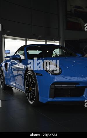 A blue sport car rests inside a modern building Stock Photo