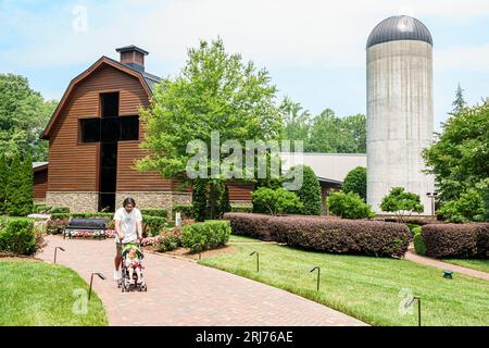 Charlotte North Carolina,Billy Graham Library,former dairy barn,stroller,family parent father daughter girl,outside exterior,building front entrance Stock Photo