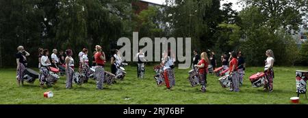 Batala Samba Band in Whitworth Park, Manchester, UK, plus other visitors to the park that afternoon, 19th August, 2023. Stock Photo