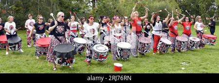 Batala Samba Band in Whitworth Park, Manchester, UK, plus other visitors to the park that afternoon, 19th August, 2023. Stock Photo