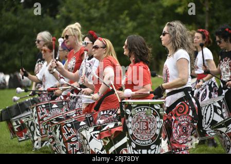 Batala Samba Band in Whitworth Park, Manchester, UK, plus other visitors to the park that afternoon, 19th August, 2023. Stock Photo