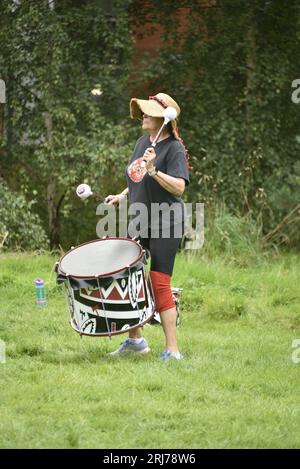 Batala Samba Band in Whitworth Park, Manchester, UK, plus other visitors to the park that afternoon, 19th August, 2023. Stock Photo