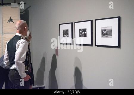 Tate Liverpool, Radical Landscapes exhibition 2022. Art gallery photography lovers looking at photography as art. Vintage exhibition prints - photographs courtesy of The Hyman Collection London. l-r (i) The Burry Man, South Queensferry, Scotland 1971. (ii) Allendale Tar Barrel Parade, Northumberland, England 1972. (iii) Castleton Garland Day, Castleton Derbyshire England 1972. 2022 2020s UK HOMER SYKES Stock Photo