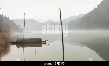 Foggy weather in the morning, there are fishing boats docked at shore Stock Photo