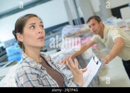 man completing paperwork in warehouse Stock Photo