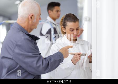 female apprentice decorator in training Stock Photo
