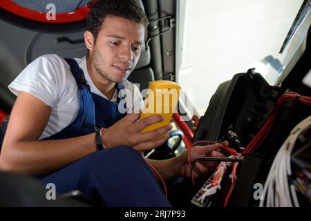 auto mechanic man with multimeter testing battery Stock Photo