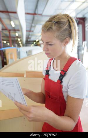 female carpenter reading the blueprint Stock Photo