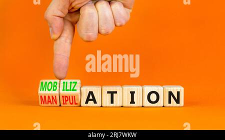 Mobilization or manipulation symbol. Concept words Mobilization Manipulation on wooden cubes. Beautiful orange background. Psychologist hand. Psycholo Stock Photo