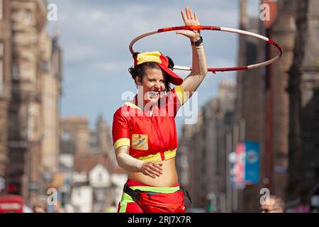 Royal Mile, Edinburgh, Scotland, UK. 21 August 2023. Final full week for the street performers on Edinburgh Festival Fringe in the High Street. Audiences still watching shows but less crowded than the weekend just past. Sunshine but still windy for those on platforms. Pictured: Amazing Gracie B performs in the sunshine with her hoops on the Royal Mile. Credit: Archwhite/alamy live news. Stock Photo