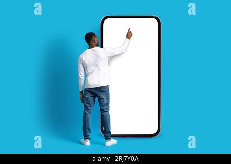 Unrecognizable african american guy touching huge phone screen Stock Photo