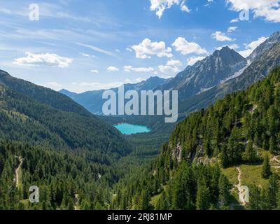 Aerial view of alpine lake Lago di Anterselva (Antholzer See) as seen from Passo Stalle (Staller Pass) in a Dolomite mountain valley with green pine f Stock Photo
