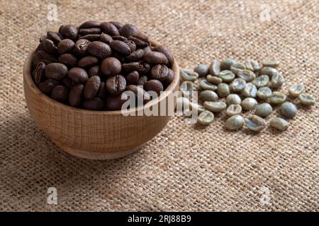 Green coffee with roasted coffee beans on burlap sack,closeup Stock Photo