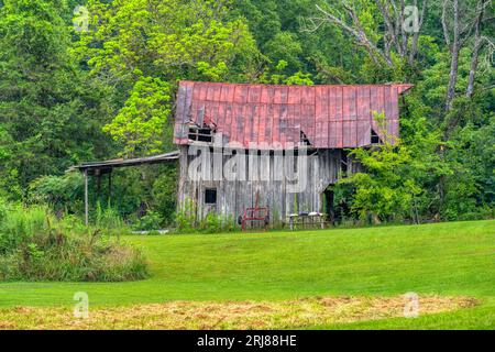 Horizontal shot of an abandoned old barn in the summer rain. Stock Photo