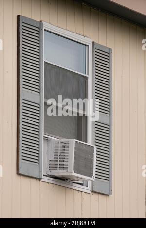 Vertical shot of an old window air conditioner in a low rent apartment window. Stock Photo