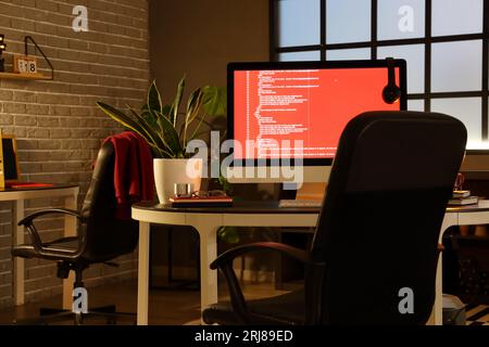 Programmer's workplace with computer in dark office Stock Photo