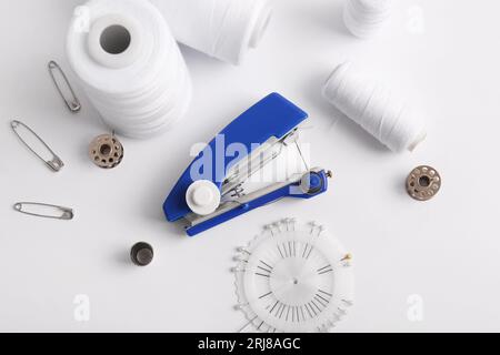 Manual sewing machine with different supplies on white background Stock Photo