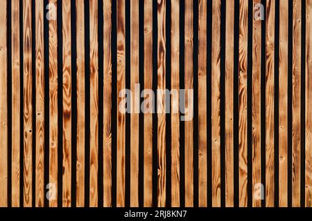 Brown wooden slats as background. Texture of vertical wood strips. Light wooden tiles. Stock Photo