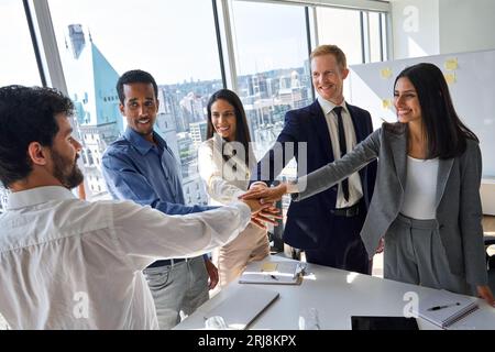 International young business team joining hands together in stack in office. Stock Photo