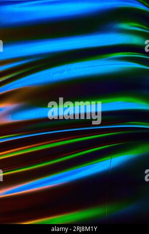 Vibrant chrome background asset with dark black between blue wavy lines with green and orange Stock Photo