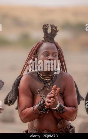 A portrait of a Himba tribe woman in traditional clothes and ornaments in a deserted landscape Stock Photo